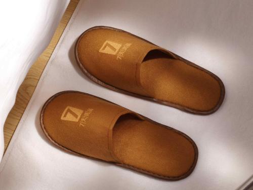 a pair of brown shoes sitting on a table at 7Days Premium Baoding Zhuozhou Development Zone Branch in Zhangcun