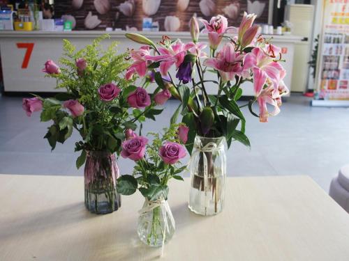 two vases filled with pink flowers on a table at 7Days Premium Yichang Gezhouba Branch in Yichang