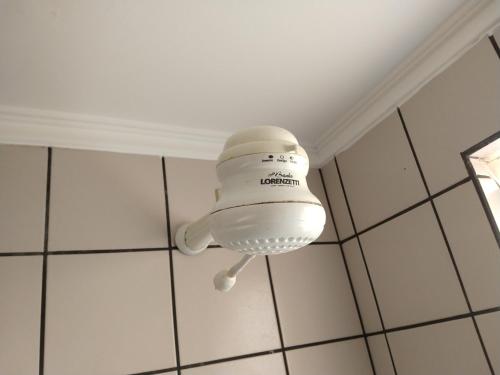 a white light hanging from the ceiling of a room at diRoma Fiori - Apartamentos JN in Caldas Novas