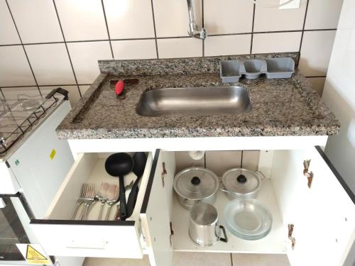 a kitchen counter with a sink and some pots and pans at diRoma Fiori - Apartamentos JN in Caldas Novas