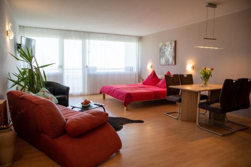 a living room with a red couch and a table at Apartment "Köhler" mit Berg- und Bodenseesicht in Oberteuringen