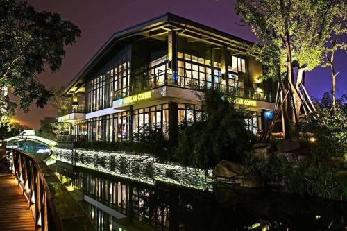 um grande edifício sobre um rio à noite em 7Days Premium Chengdu Global Center New Exhibition Branch em Chengdu