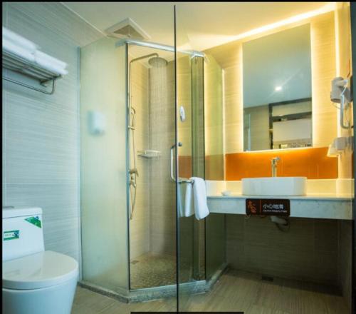 La salle de bains est pourvue d'une douche, d'un lavabo et de toilettes. dans l'établissement 7Days Premium Kunming University Town Subway Station Branch, à Huacheng