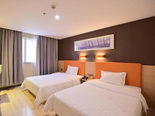 una habitación de hotel con 2 camas en una habitación en 7Days Premium Laizhou City Government Branch, en Laizhou