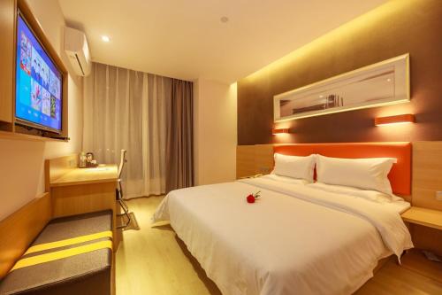 a hotel room with a large bed and a tv at 7Days Premium Chengdu East Railway Station Subway Station Branch in Chengdu