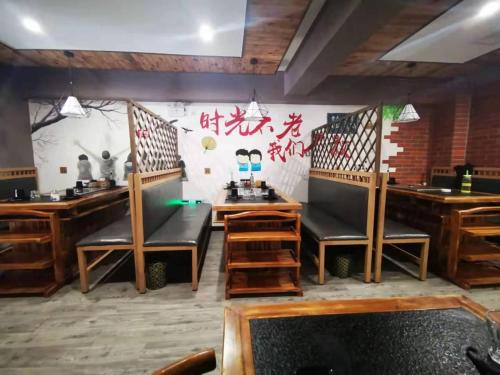 a dining room with chairs and a wall with writing at 7Days Premium Chengde University City High Speed Rail Station Branch in Chengde