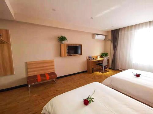 a hotel room with two beds and a television at 7Days Premium Chengde University City High Speed Rail Station Branch in Chengde