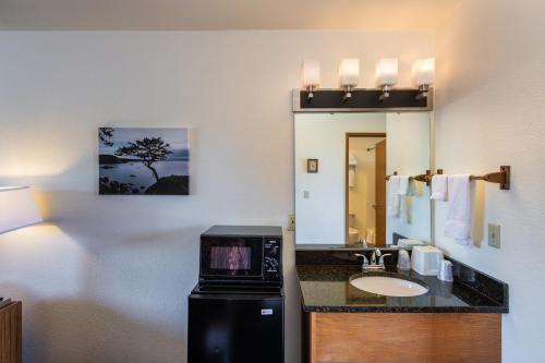 a bathroom with a sink and a counter with a mirror at Cap Sante Inn in Anacortes
