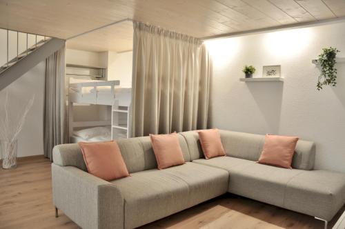 ein Wohnzimmer mit einem Sofa und einem Etagenbett in der Unterkunft Modern Family Apartment in Interlaken Center in Interlaken