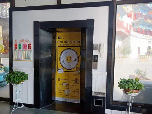 una máquina de tienda naranja con un reloj en ella en 7Days Premium Qianjiang Railway Station Lobster City Branch, en Qianjiang