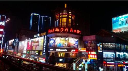 a lit up city at night with neon signs at 7Days Premium Changsha Wuyi Square Subway Station Branch in Changsha