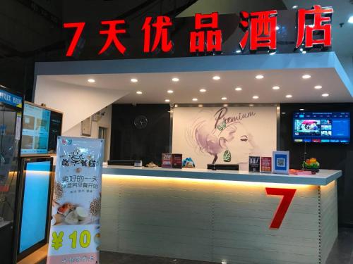 un restaurant avec un comptoir et un panneau en arrière-plan dans l'établissement 7Days Premium Changsha Wuyi Square Subway Station Branch, à Changsha