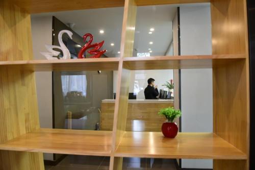 a reflection of a man in a mirror at 7Days Premium Luoyang Peony Park Shanghai Market Branch in Luoyang