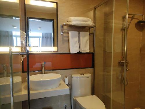 a bathroom with a toilet and a sink and a shower at 7Days Premium Dingxi Train Station Branch in Dingxi