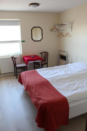 1 dormitorio con 1 cama, mesa y sillas en Sunnuberg Guesthouse, en Hofsós