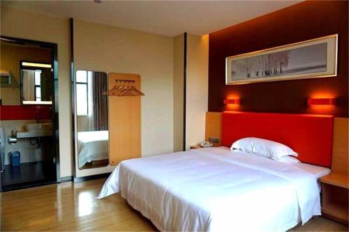 Schlafzimmer mit einem großen Bett mit einem roten Kopfteil in der Unterkunft 7Days Premium Nanchong Silk Road Branch in Nanchong