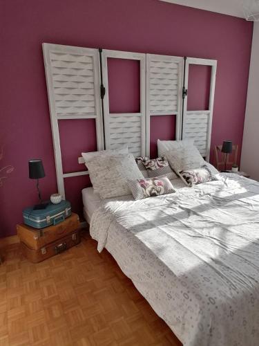 - une chambre avec un grand lit aux murs roses dans l'établissement Propriété de charme-6 pers Le Pouldu, à Clohars-Carnoët