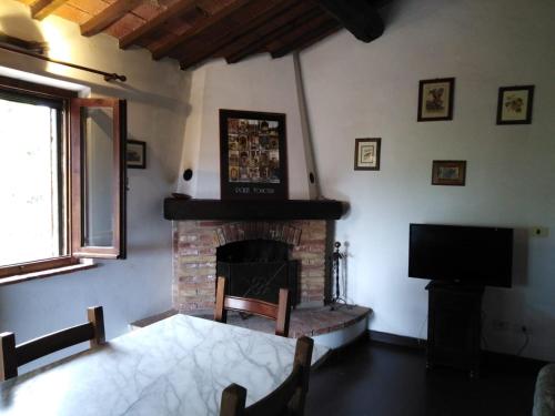 salon z kominkiem i telewizorem w obiekcie Agritur Villa Osvaldo Castiglione del Lago Perugia Colazione Piscina acqua salata w mieście Castiglione del Lago