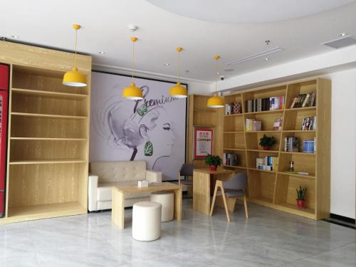 a library with wooden shelves and a table and chairs at 7Days Premium Anyang Tangyin Yuefei Temple Branch in Anyang