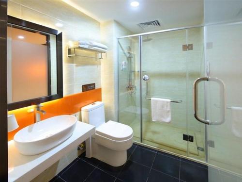 a bathroom with a toilet and a glass shower at 7Days Premium Fuzhou Dongxiang High Speed Railway Station Branch in Fuzhou