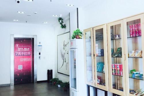 a room with wooden shelves and a refrigerator at 7Days Premium Changsha Hongxing South Bus Station Branch in Changsha