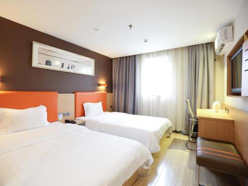 a hotel room with two beds and a window at 7Days Premium Changsha Hongxing South Bus Station Branch in Changsha