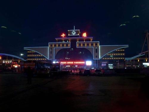 a large building with a clock tower at night at 7Days Premium Shiyan Renmin Road Sanyan Coach Station Branch in Shiyan