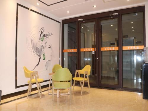 a room with chairs and a picture of a woman at 7Days Premium Jinan West Railway Station Branch in Jinan