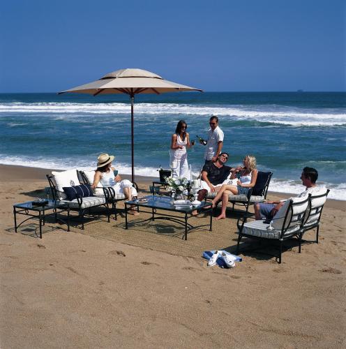 a group of people sitting around a table on the beach at Bentley on the Beach in Umhlanga