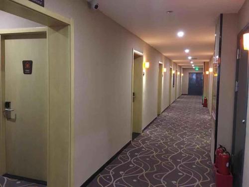 a hallway of a hotel with a long corridor at 7Days Premium Xingtai Zhongxing West Street Gushun Branch in Xingtai