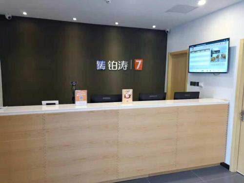 a reception counter at a hotel with a television at 7Days Premium Xingtai Zhongxing West Street Gushun Branch in Xingtai