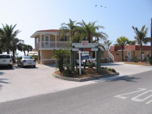 a street sign in front of a house with palm trees at A Beach Retreat on Casey Key in Venice