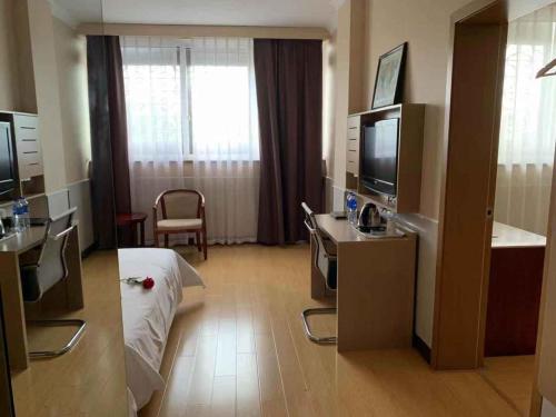 a hotel room with a bed and a television at 7Days Premium Suzhou Tongli Ancient Town Branch in Suzhou
