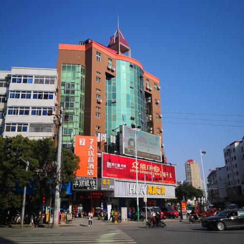 ein hohes Gebäude in einer Stadt mit Leuten, die auf der Straße spazieren in der Unterkunft 7Days Premium Ji'an Taihe Gongnongbing Avenue Branch in Ji'an