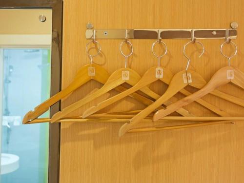 a bunch of wooden utensils hanging on a wall at 7Days Premium Xiamen Airport Xianglu Branch in Xiamen