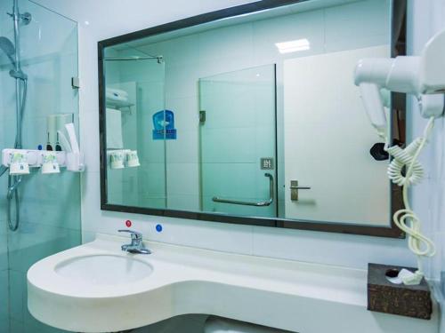 a bathroom with a sink and a large mirror at 7Days Premium Xiamen Airport Xianglu Branch in Xiamen