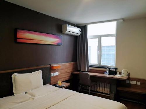 a hotel room with a bed and a desk and a window at 7Days Premium Harbin Central Street Sophia Church Branch in Harbin
