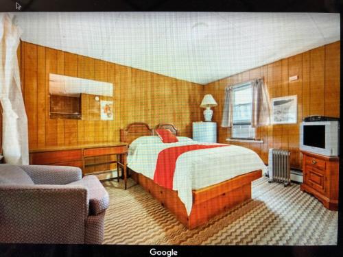 a bedroom with a bed and a tv and a couch at Monmouth OYO in Neptune City