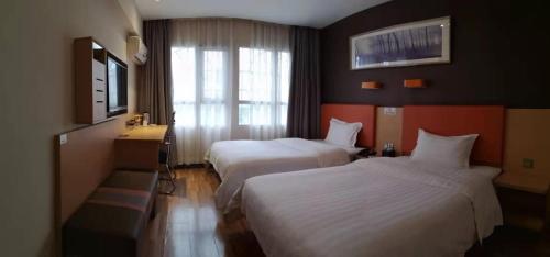Tempat tidur dalam kamar di 7Days Premium Zunyi Dingzikou Branch
