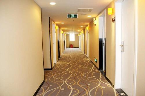 um corredor de um edifício de escritórios com um corredor alcatifado em 7Days Premium Haikou Pearl Plaza Wuzhishan Road Branch em Haikou