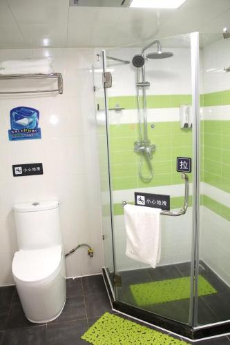 ein Bad mit einer Dusche, einem WC und einer Glastür in der Unterkunft 7Days Premium Haikou Pearl Plaza Wuzhishan Road Branch in Haikou