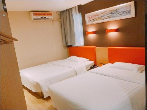 two beds in a hospital room with white sheets at 7Days Premium Chendu Kuanzhai Alley Branch in Chengdu