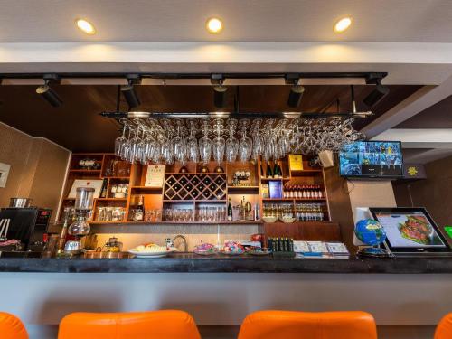 a bar with orange chairs and glasses on the wall at 7Days Premium Lanzhou New District Airport Branch in Lanzhou
