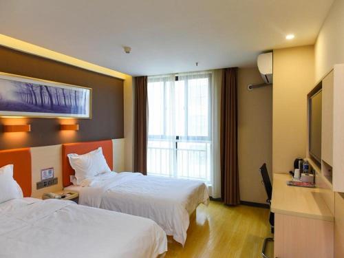 a hotel room with two beds and a window at 7Days Premium Lanzhou New District Airport Branch in Lanzhou