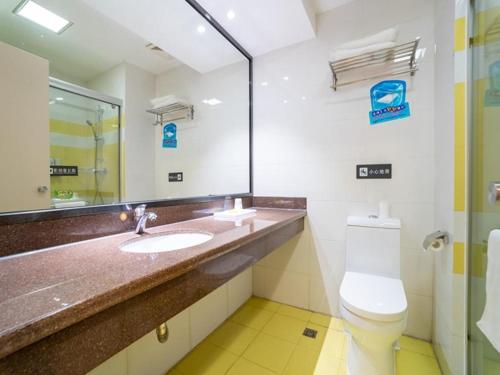 bagno con lavandino, servizi igienici e specchio di 7Days Premium Xiamen Airport Branch a Xiamen