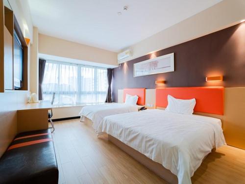 a hotel room with two beds and a desk at 7Days Premium Xiamen Airport Branch in Xiamen