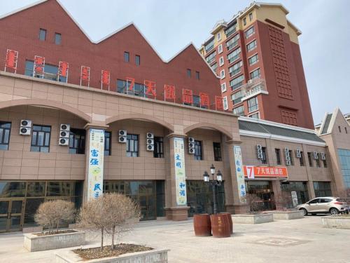 um grande edifício numa cidade com estacionamento em 7Days Premium Bole Tuanjie South Road Lanhu Courtyard Branch em Dalt