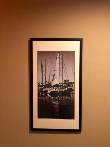 a framed picture of a boat on a wall at 7Days Premium Chengdu Xinjin Rulin Road Subway Station Branch in Chengdu