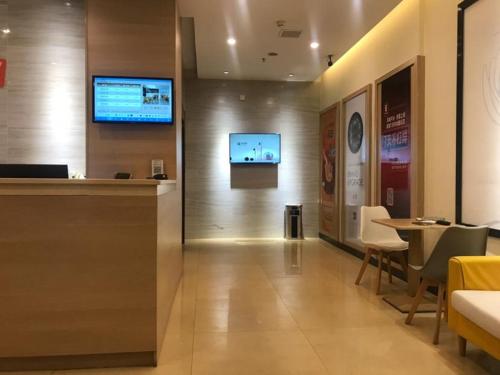 a lobby with a tv on the wall and a table at 7 Days Premium Yichun Gaoshi Road Branch in Yichun