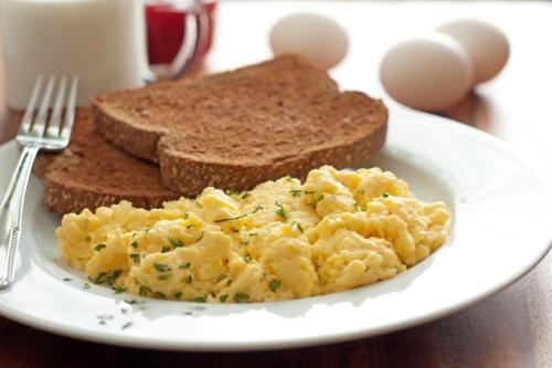 a plate of scrambled eggs and toast on a table at Jayleen Clarke Quay Hotel in Singapore